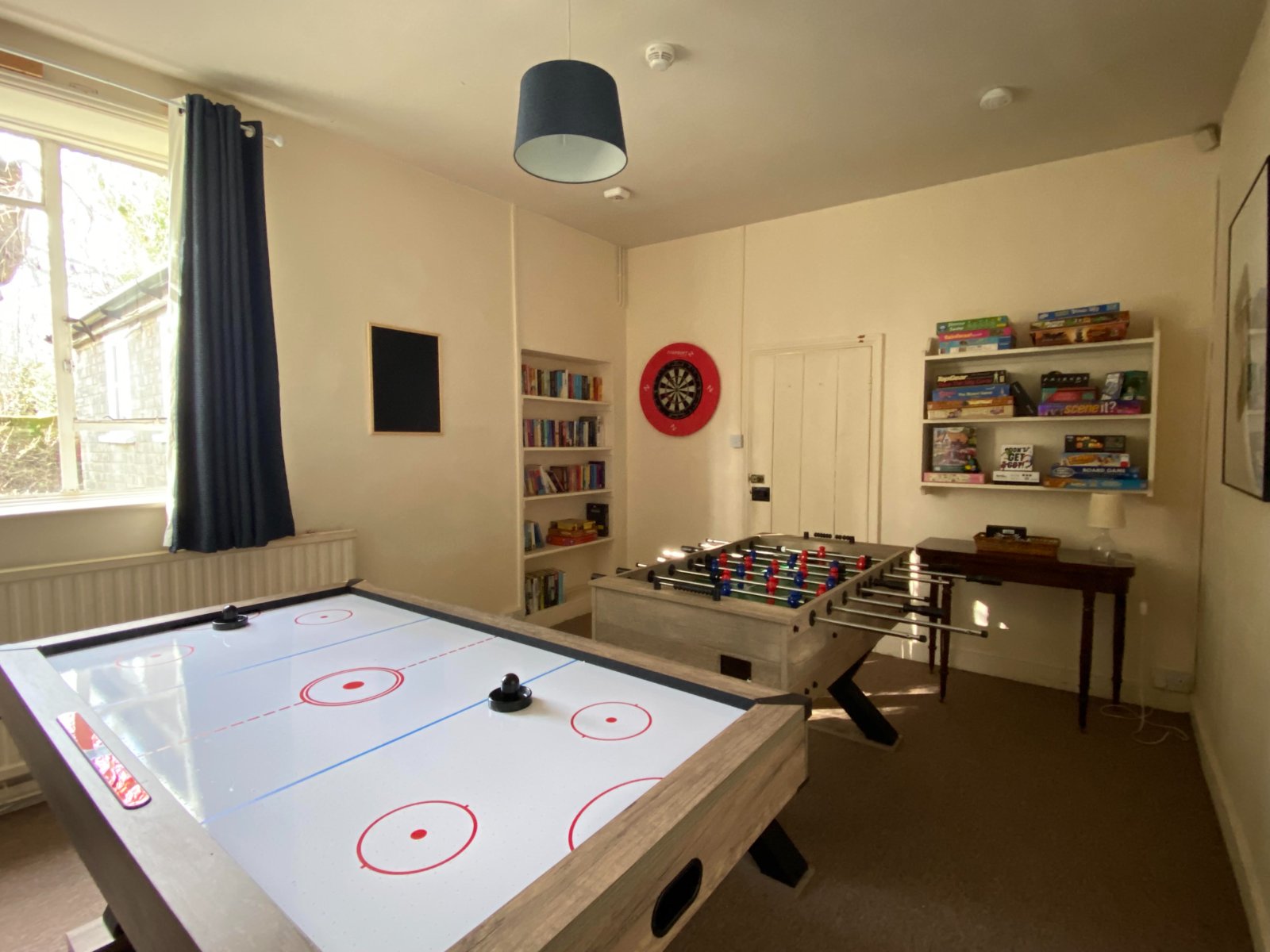 Games room with air hockey, table football and shelves of board games