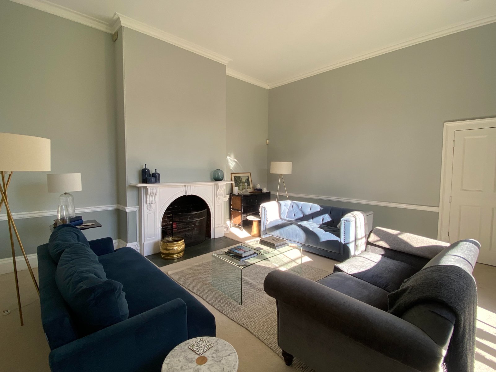 Refurbished drawing room with velvet sofas around the fireplace