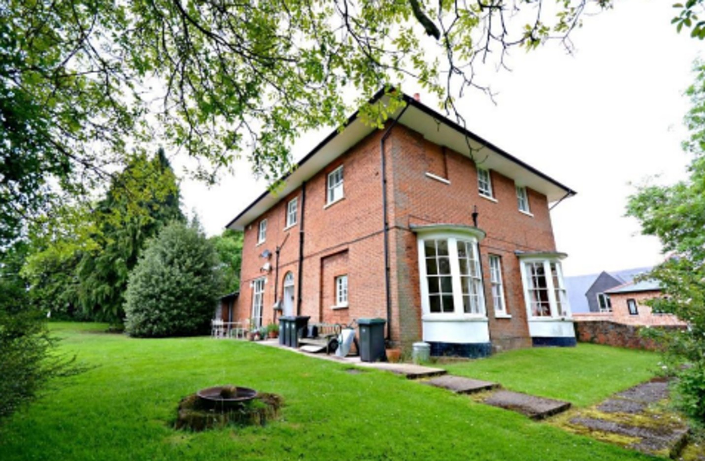 Georgian manor house from the garden, red brick with white bay windows